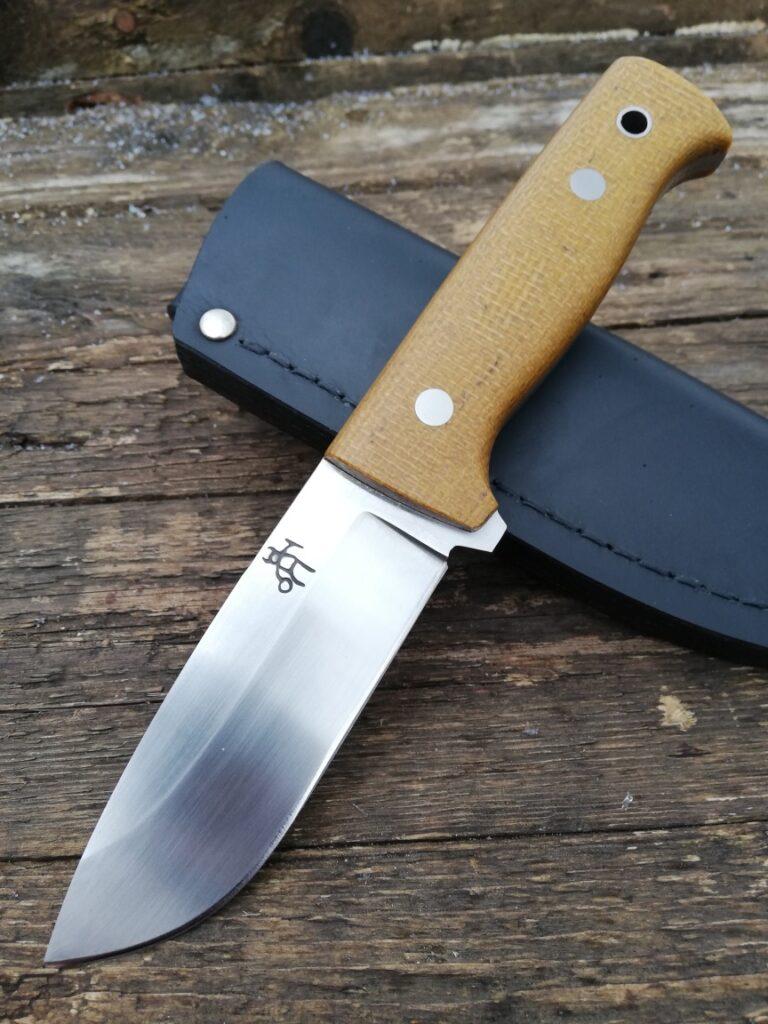 Bushcrafter 11 bushcraft knife with a purple Micarta handle on a brown leather sheath